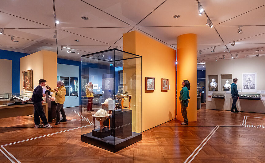 Personen schauen sich die Ausstellung an.